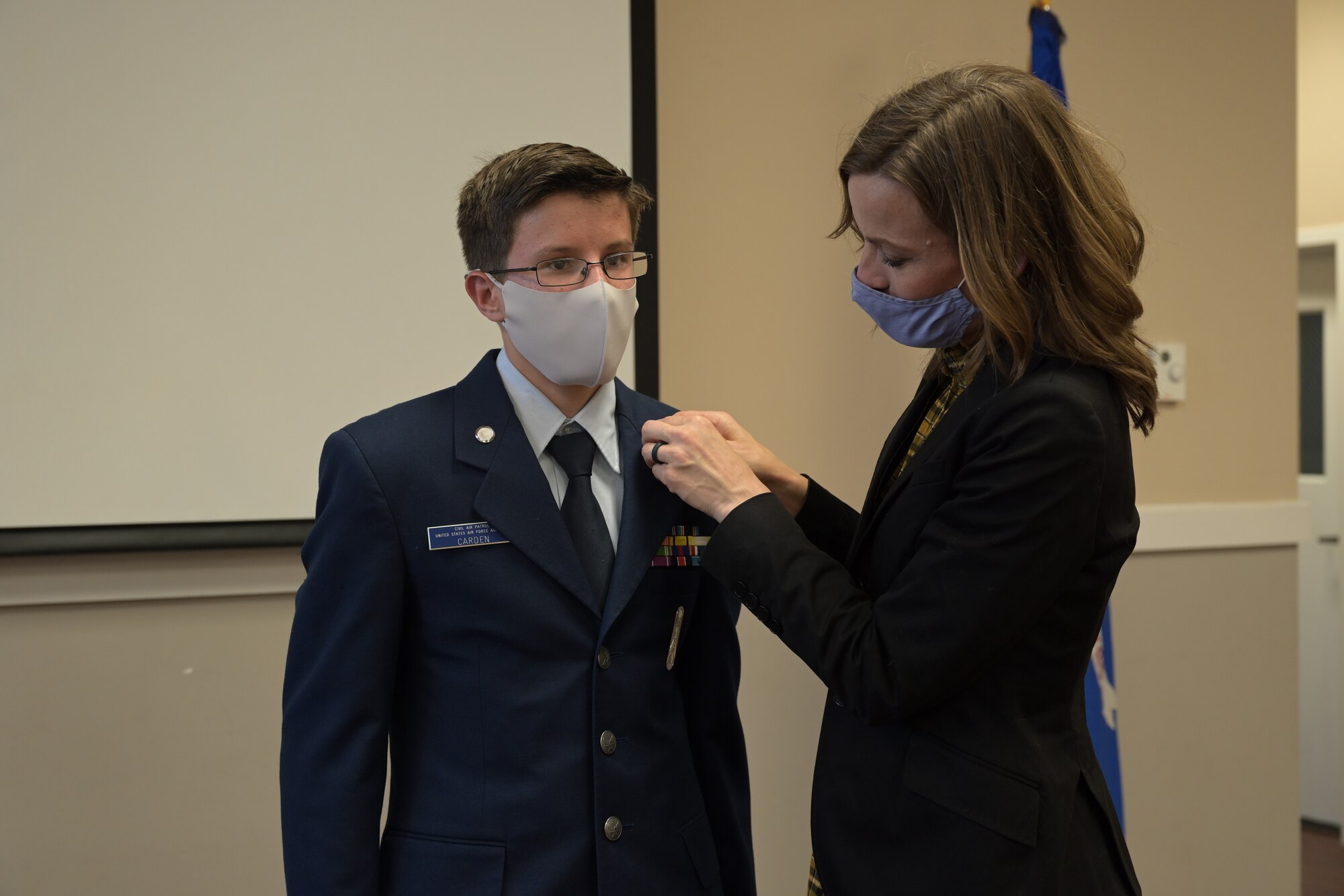 Golden Triangle Composite Squadron Civil Air Patrol cadet 2nd Lt. Matthew Carden, incoming cadet commander is pinned by his mother, Kristina Carden, during a change of command ceremony, Apr.1, 2021, on Columbus Air Force Base, Miss. Nationally there is almost 21,000 cadets and 33,000 senior members in numerous squadrons servicing the communities, state, and Nation as volunteers. (U.S. Air Force photo by Airman 1st Class Jessica Haynie)