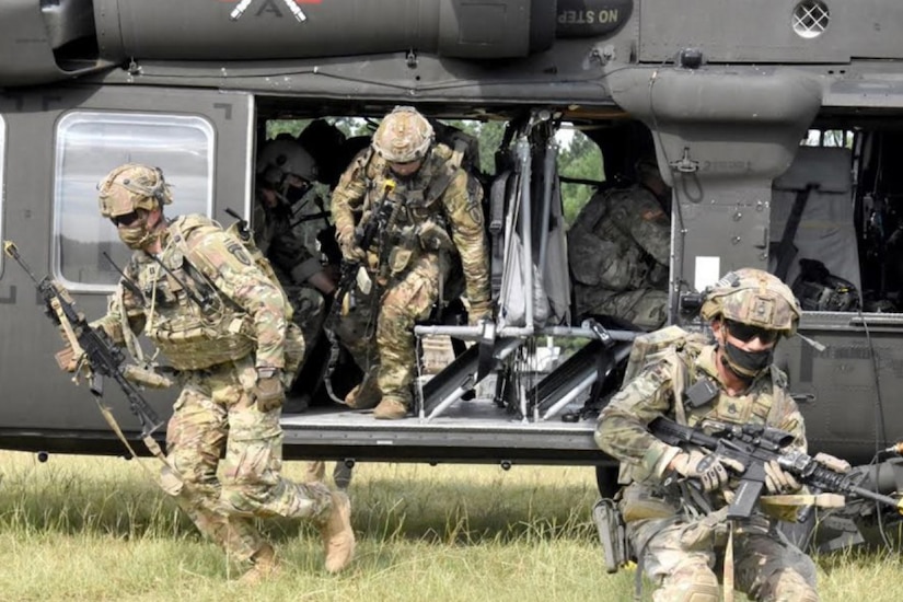 Soldiers exit a helicopter.