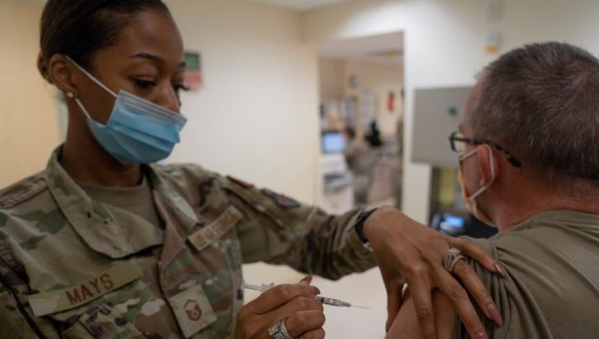 Air Force Master Sgt. La'Kisha Mays, 81st Healthcare Operations Squadron medical specialties flight chief, administers the COVID-19 vaccine to Air Force Col. (Dr.) Wayne Latack, 81st Medical Group internal medicine residency program director, at Keesler Medical Center (Photo by: Air Force Senior Airman Kimberly Mueller, 81st Training Wing Public Affairs).