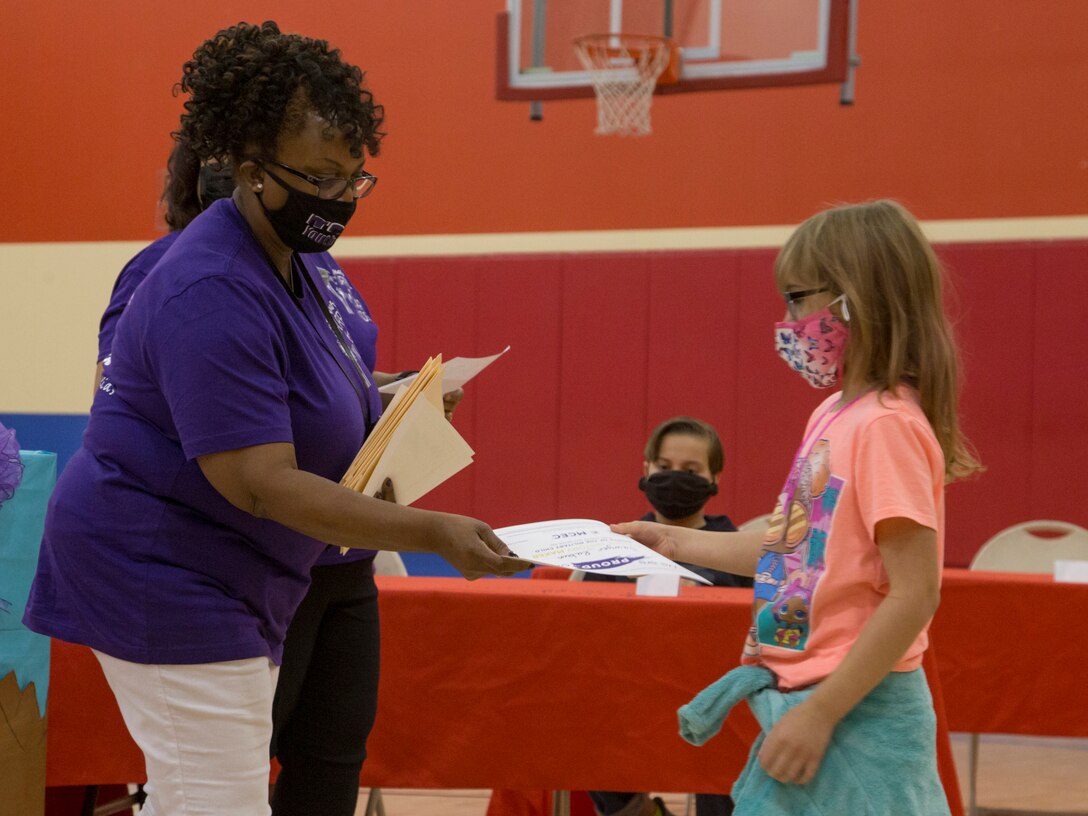 A child accepts an award during a ceremony to addresses military children at the Youth Center on MCAS Yuma, Ariz., April 14, 2021. The ceremony was held to honor military children by highlighting their unique experiences. (U.S. Marine Corps photo by Cpl. Joseph Exner)