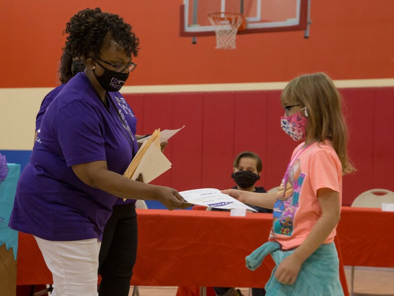 A child accepts an award during a ceremony to addresses military children at the Youth Center on MCAS Yuma, Ariz., April 14, 2021. The ceremony was held to honor military children by highlighting their unique experiences. (U.S. Marine Corps photo by Cpl. Joseph Exner)