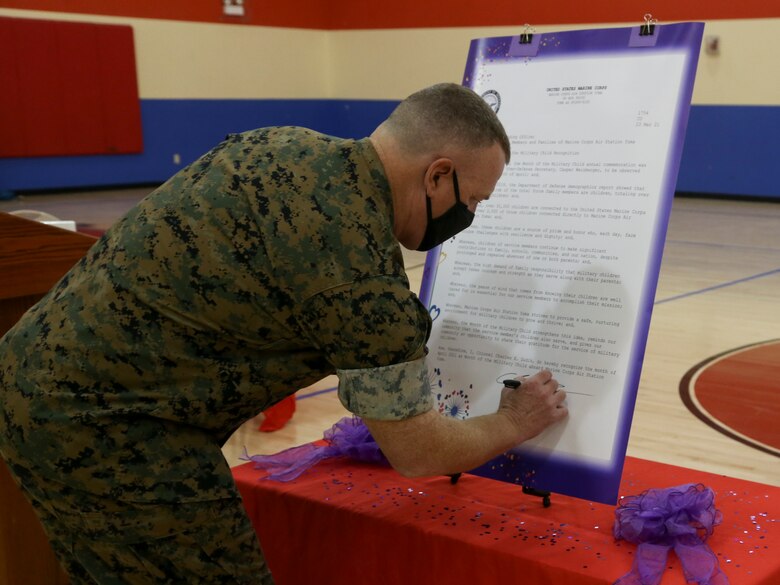 U.S. Marine Corps Col. Chuck Dudik, commanding officer of Marine Corps Air Station (MCAS) Yuma, signs a proclamation in recognition of military children at the Youth Center on MCAS Yuma, Ariz., April 14, 2021. The ceremony was held to honor military children by highlighting their unique experiences. (U.S. Marine Corps photos by Cpl. Joseph Exner)