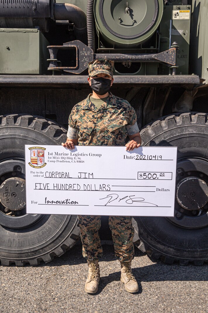 U.S. Marine Corps Cpl. Kudy L. Jim was awarded a $500 check by Brig. Gen. Bobbi Shea during a 1st MLG Innovation Awards Program ceremony.