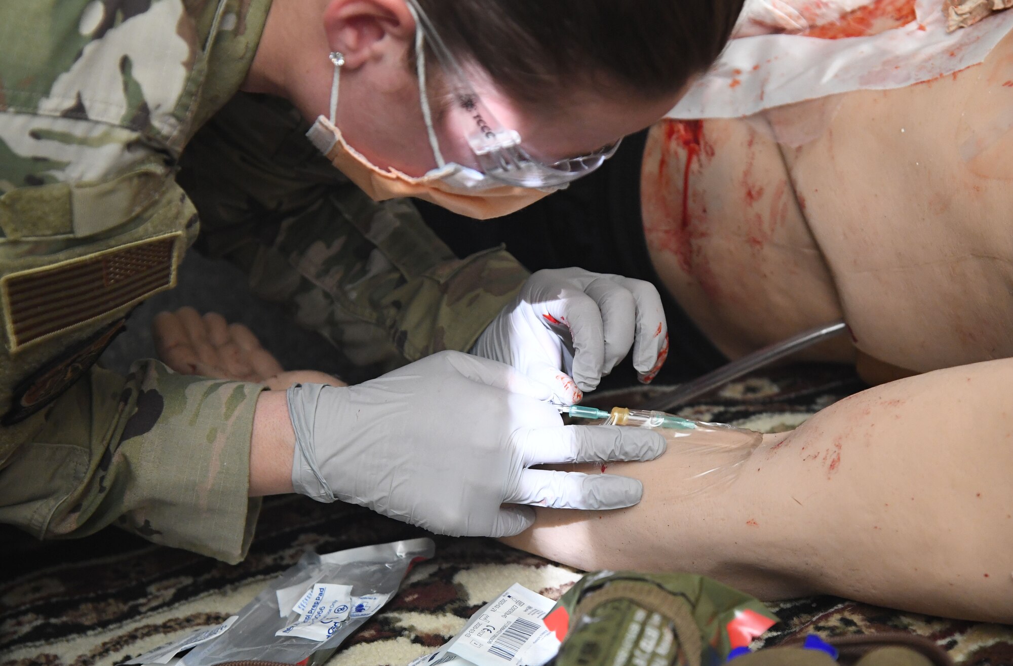 U.S. Air Force Airman 1st Class Andrea Roberts, 81st Medical Support Squadron medical technician, participates in the Tactical Combat Casualty Care training program inside the Locker House at Keesler Air Force Base, Mississippi, March 30, 2021. The training offers hands-on training in a simulated deployed environment using evidence based, life saving techniques and strategies to provide the best trauma care possible on the battlefield. (U.S. Air Force photo by Kemberly Groue)
