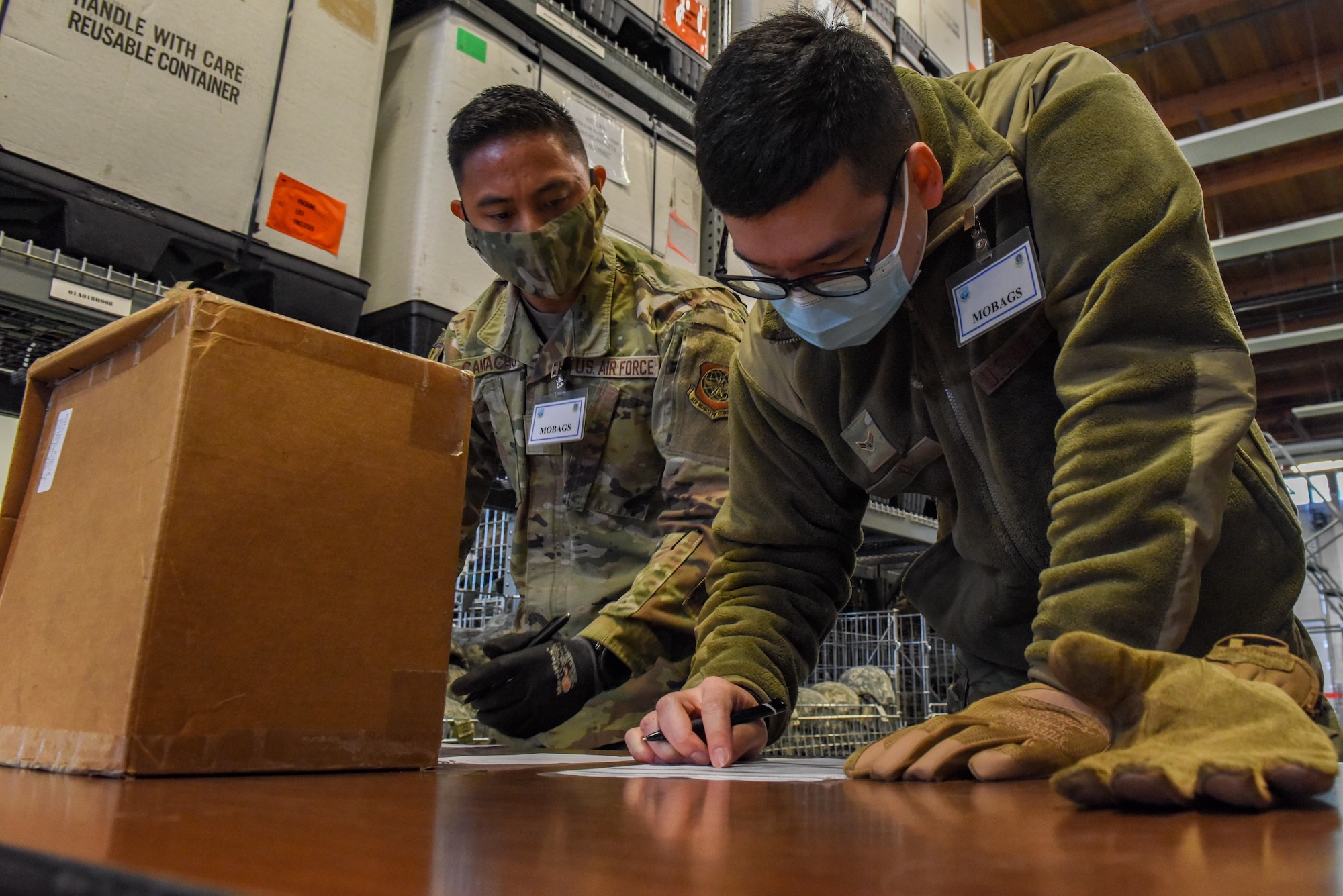U.S. Air Force Airman 1st Class Toby Yi, and U.S. Air Force Senior Airman Isaiah Camacho, material management Airmen with the 627th Logistics Readiness Squadron issue deployment gear as part of Exercise Rainer War at Joint Base Lewis-McChord, Washington, April 20, 2021. Exercise Rainier War tests the 62nd Airlift Wing’s capability to plan, generate and execute a deployment tasking, sustain contingency operations, demonstrate full spectrum readiness while in a contested, degraded and operationally limited environment. (U.S. Air Force photo by Airman Charles Casner)