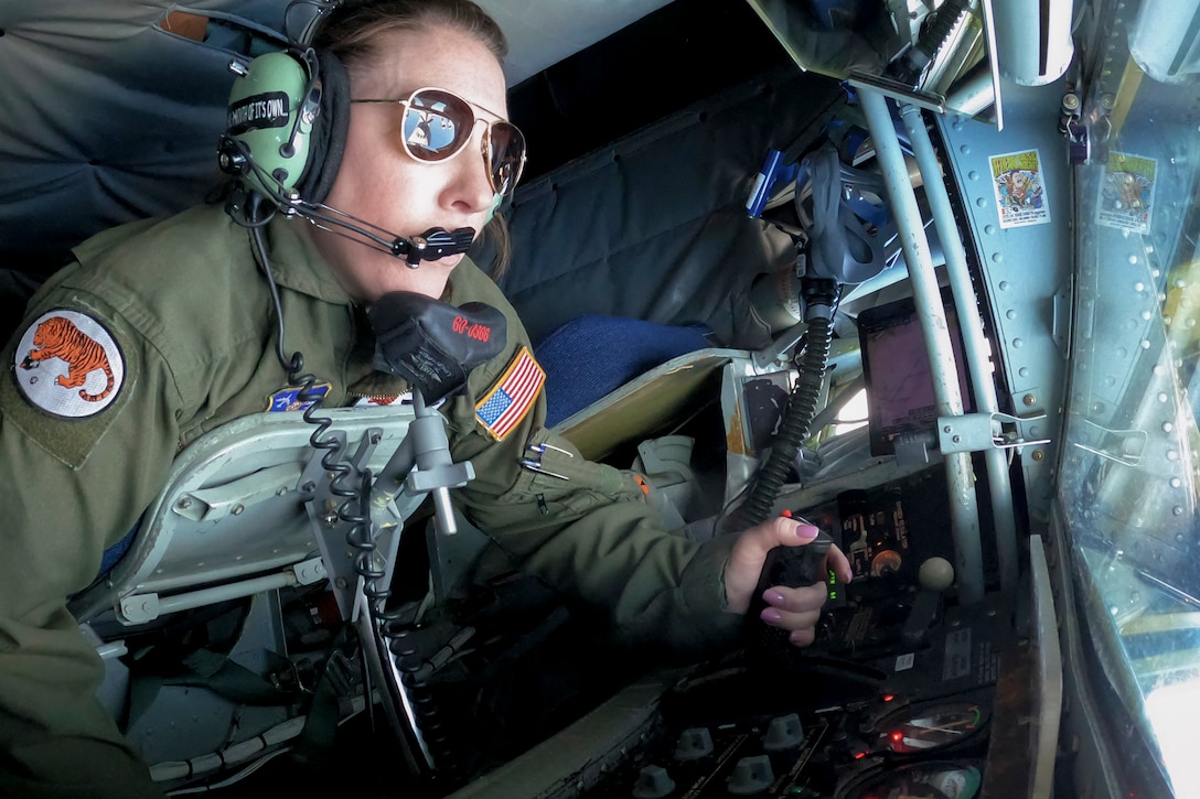 An airman operates controls inside an aircraft.
