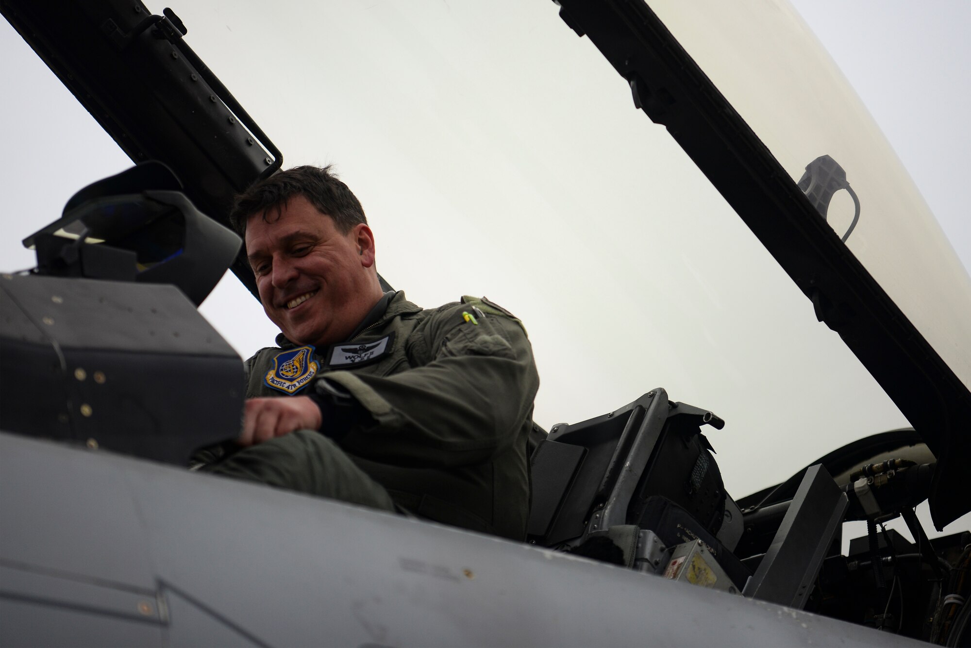 A pilot gets out of a jet.