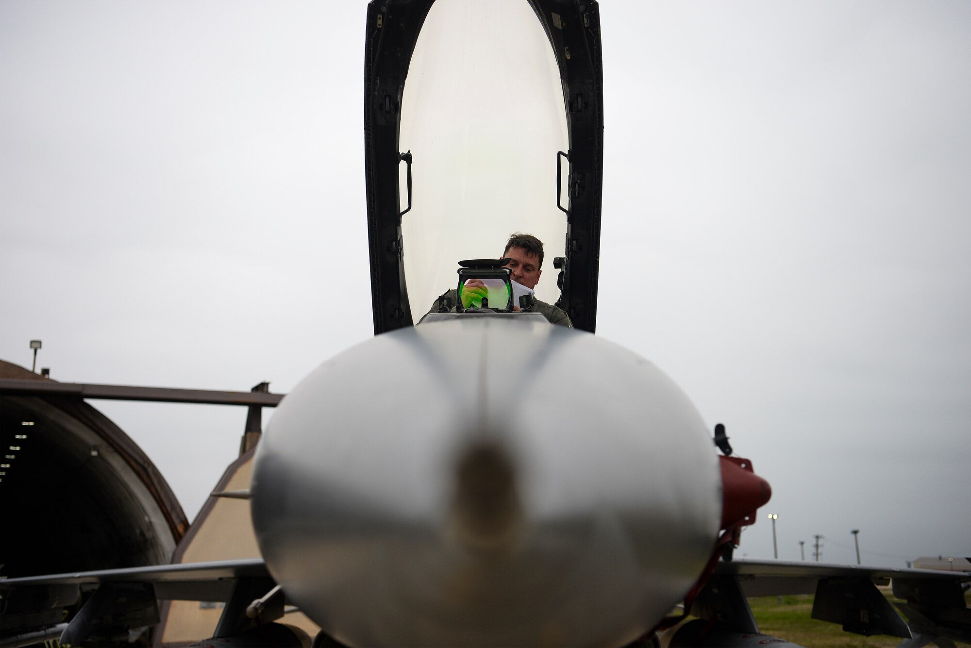 A pilot gets out of a jet.