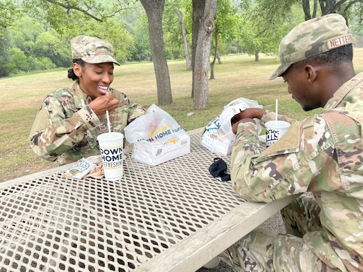 Tech. Sgt. Nessie McCray, 344th Training Squadron, and her son, Airman Basic Jaylen Netterville, 343rd Training Squadron, share lunch at Joint Base San Antonio-Lackland, Texas, April 15, 2021. Both look forward to graduating and beginning their new careers. (U.S. Air Force photo by Agnes Koterba)