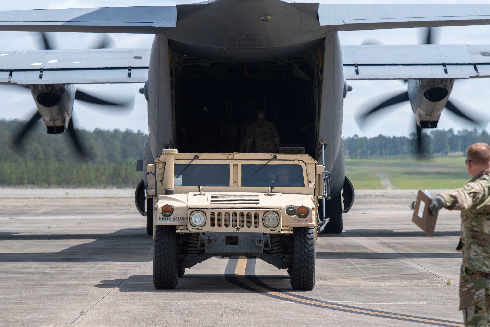 A Humvee is loaded onto a C-130J