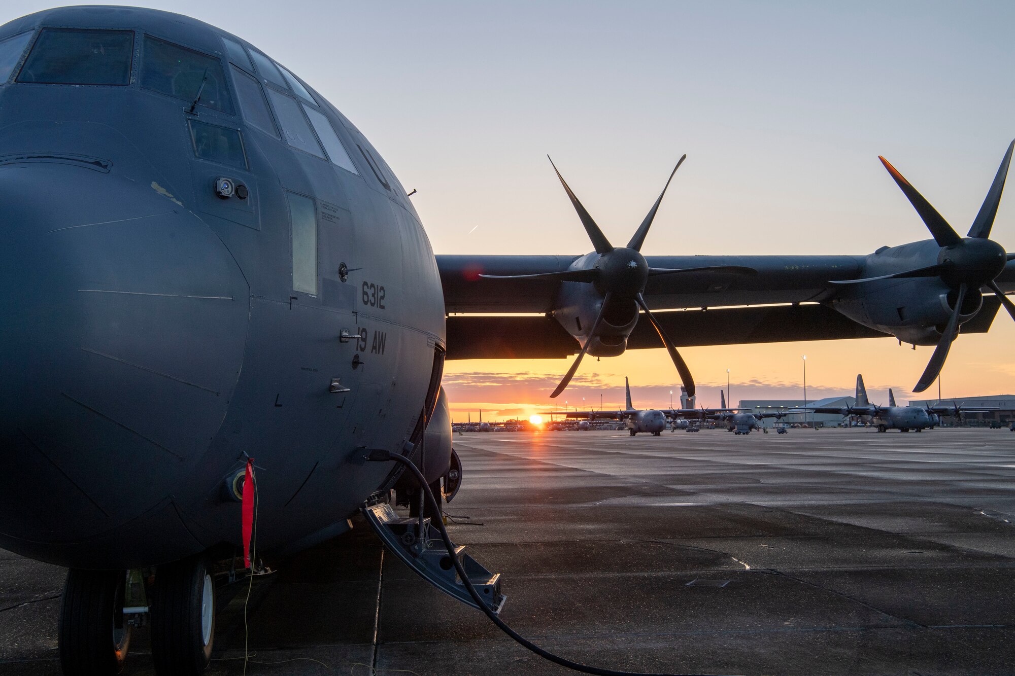 A C-130J sits on the flightline