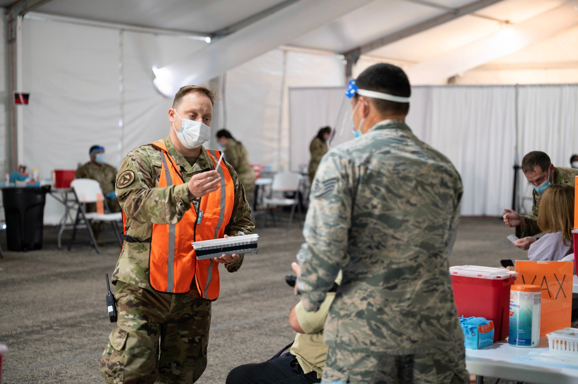 An Air Force advanced nurse practitioner distributes a COVID-19 vaccine.