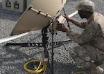Alabama National Guard Spc. Anthony Hayes, 115th Expeditionary Signal Battalion, April 13, 2021 monitors the signal strength from the Tampa satellite dish that handled communications and data traffic during the Fort Knox, Kentucky, based 1st Theater Sustainment Command's expeditionary command post validation exercise at Camp Arifjan, Kuwait. Hayes, whose battalion is deployed to Camp Buerhing, Kuwait, said he appreciated getting real-world, unscripted training working in the ECP validation exercise. (U.S. Army photo by Staff Sgt. Neil W. McCabe)