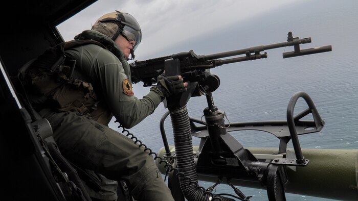 U.S. Marine Corps Gunnery Sgt. Scott Schamber, a UH-1Y Venom crew chief with Marine Light Attack Helicopter Squadron (HMLA) 267, fires an M240D machine gun during live-fire training as part of a mission rehearsal exercise off the coast of Okinawa, Japan, April 14, 2021. The MRX served as a culminating event for HMLA-267 as they near the end of their time in Okinawa as part of the Unit Deployment Program.