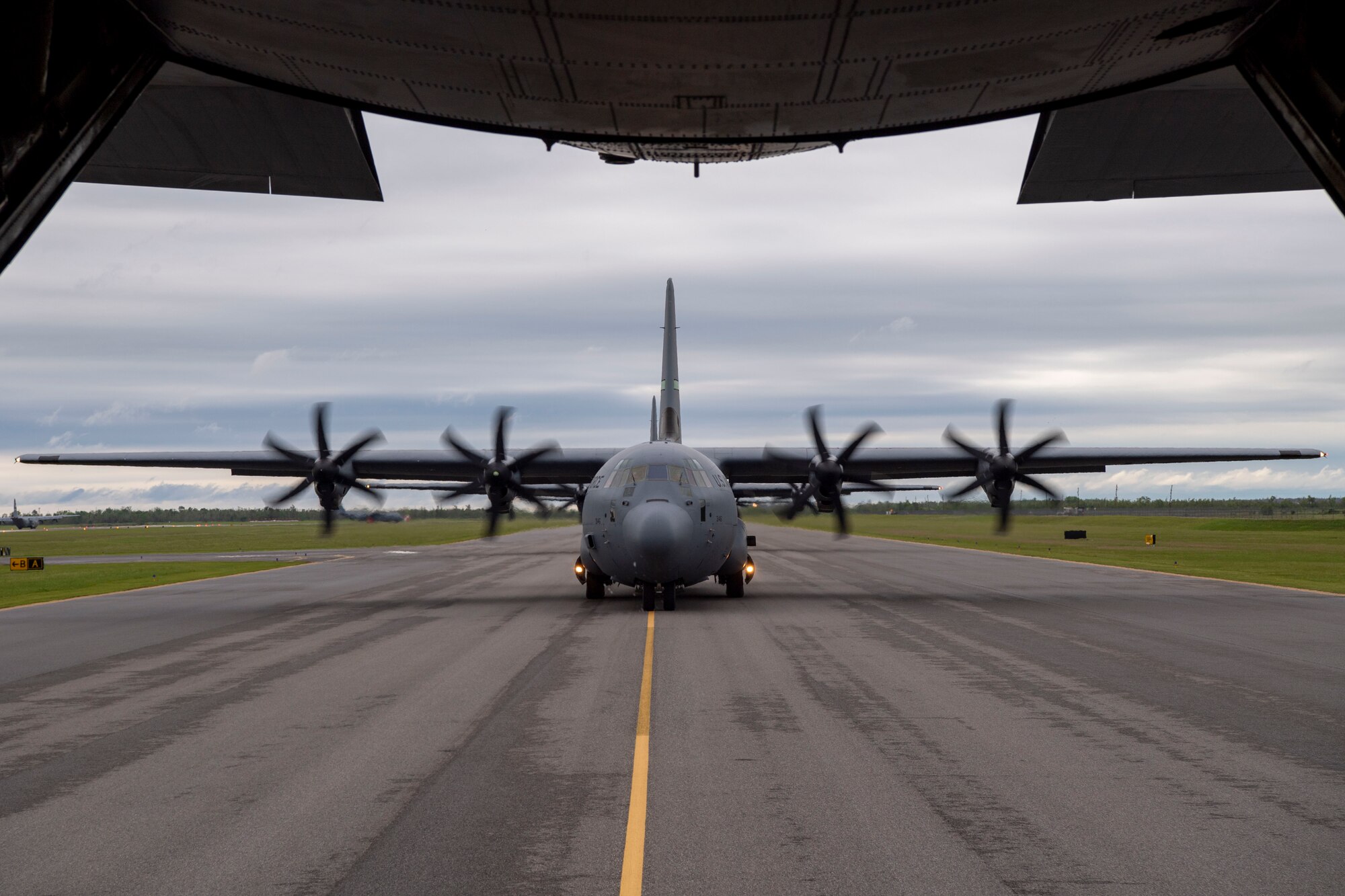 A group of C-130Js taxi on the flightline