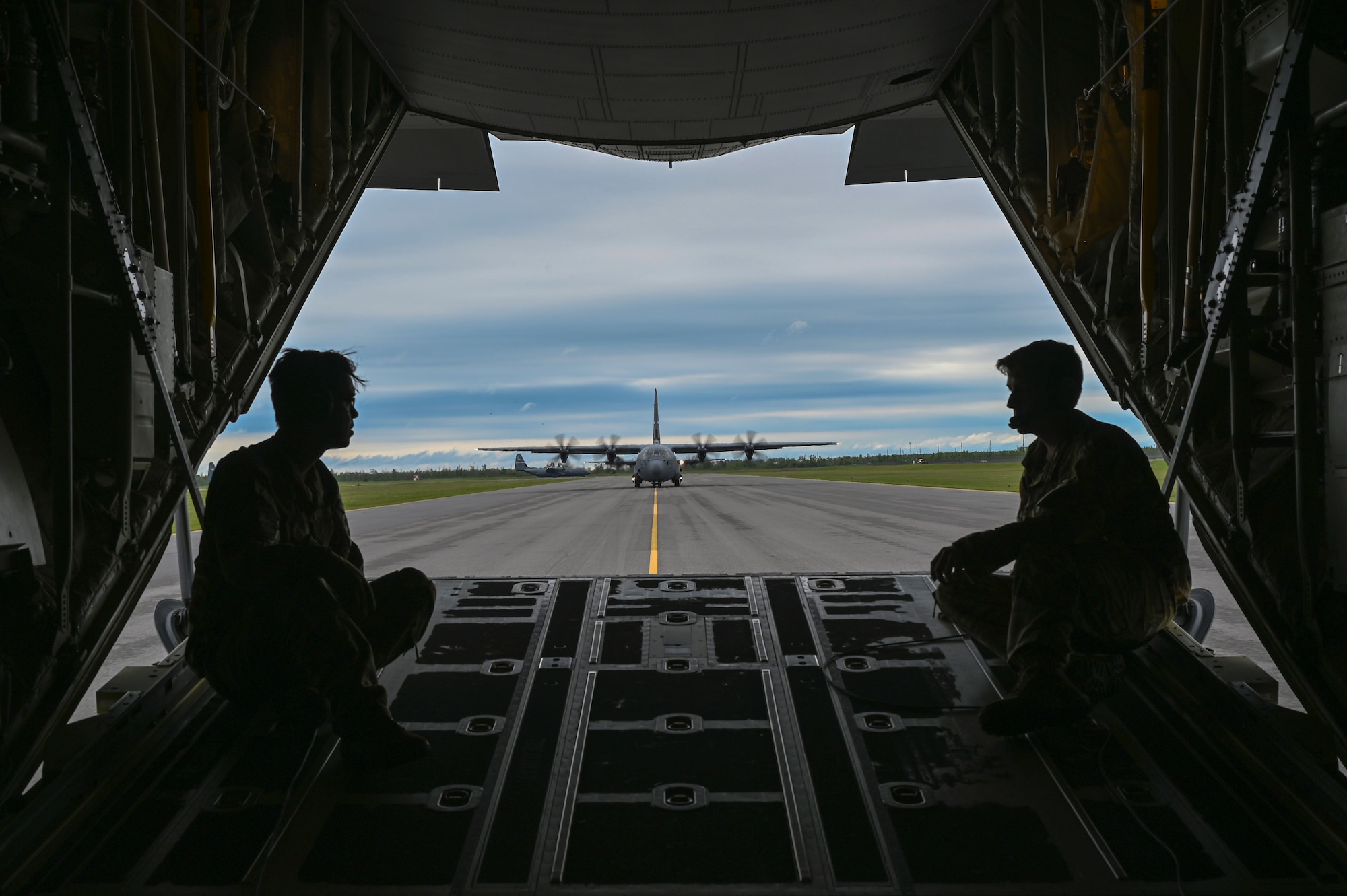 Loadmasters look on as C-130Js arrive
