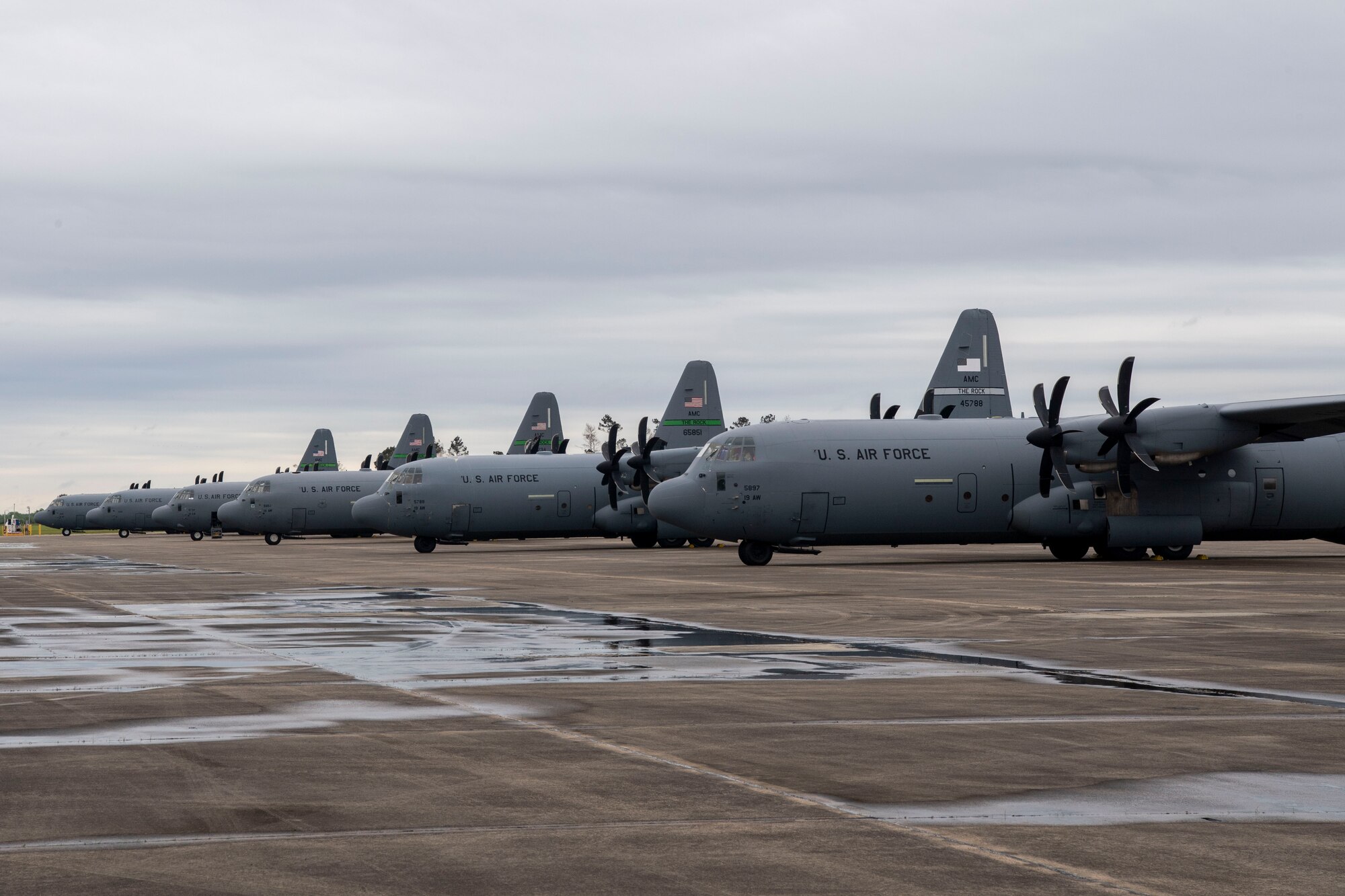 C-130Js are parked on the flightline