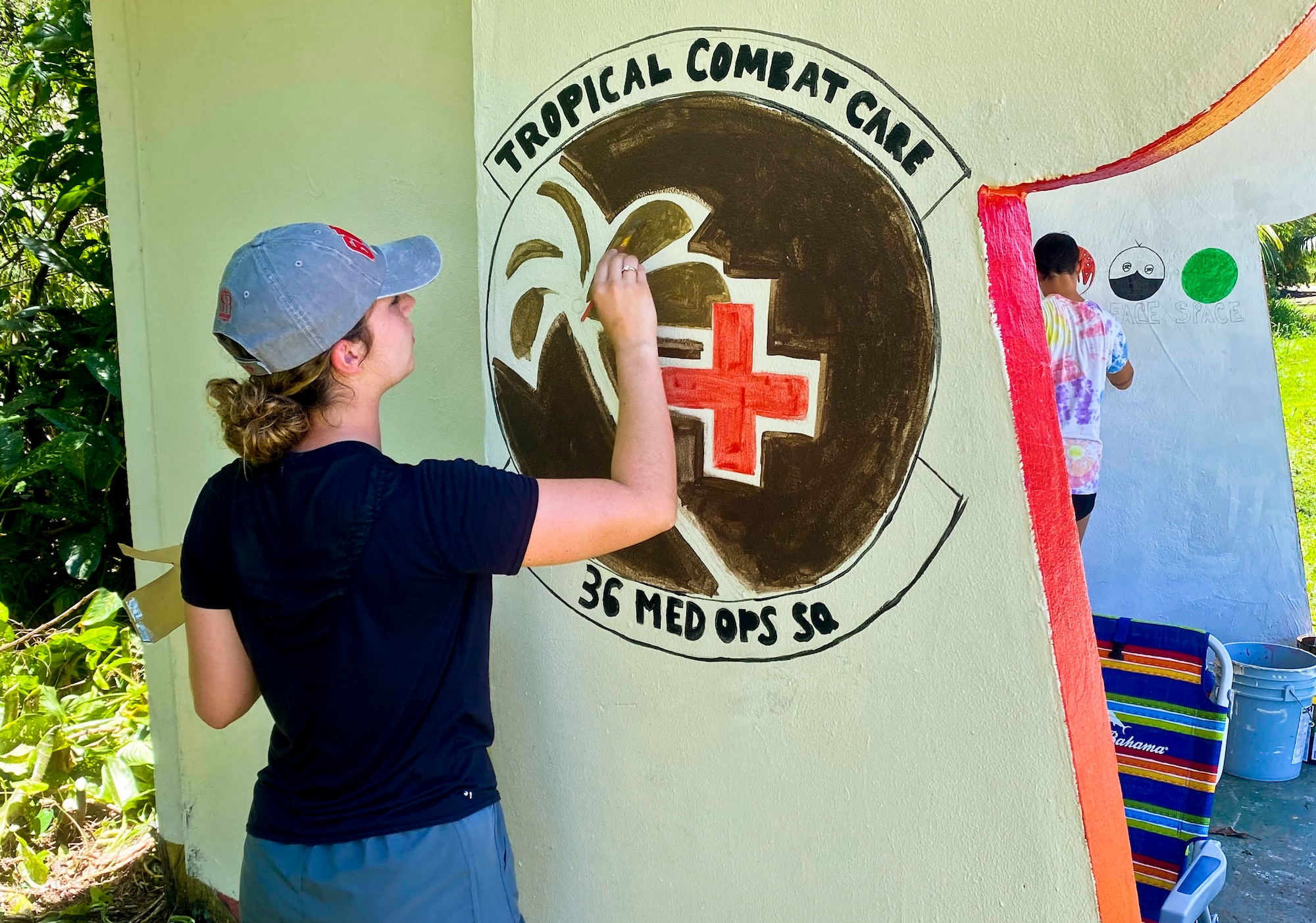 U.S. Air Force Airman 1st Class Brandie Bleess, 36th Healthcare Operations Squadron family health technician, paints a bus stop in Agat, Guam, April 17, 2021. Nearly a dozen 36th HCOS Airmen and family members joined Agat Mayor’s Office staff to repaint two village bus stops through the Andersen Air Force Base Sister Village Sister Squadron program, in which squadron volunteers collaborate in events with Guam residents to strengthen their friendship and partnership. (Photo courtesy of Tech. Sgt. Brittany Wallace)
