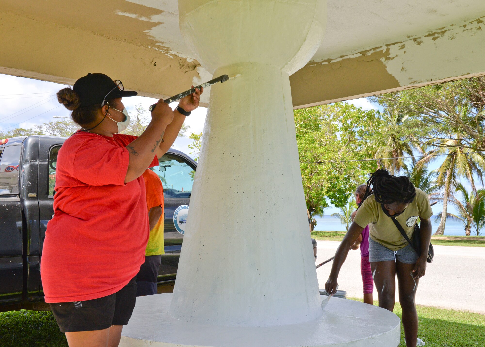 Chaunice Nauta, an Agat Mayor’s Office maintenance worker, and U.S. Air Force Senior Airman Alexis Northcutt, 36th Healthcare Operations Squadron medical logistics technician, paint a bus stop in Agat, Guam, March 20, 2021. Nearly a dozen 36th HCOS Airmen and family members joined Agat Mayor’s Office staff to repaint two village bus stops through the Andersen Air Force Base Sister Village Sister Squadron program, in which squadron volunteers collaborate in events with Guam residents to strengthen their friendship and partnership. (U.S. Air Force photo by Alana Chargualaf)