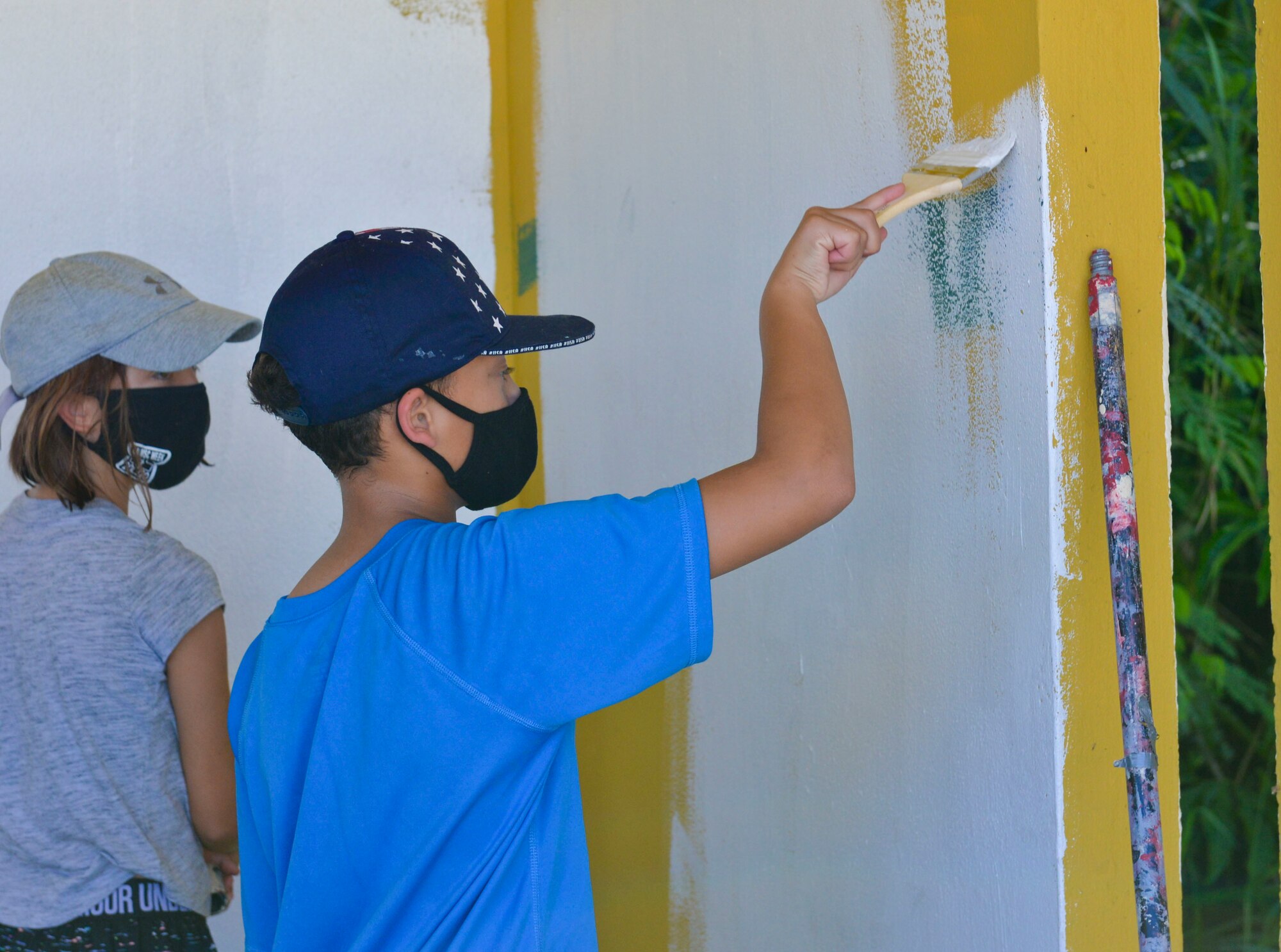 Damerin Pullis, son of U.S. Air Force Tech. Sgt. Brittany Wallace, 36th Healthcare Operations Squadron noncommissioned officer in charge of pharmacy supply, paints a bus stop in Agat, Guam, March 20, 2021. Nearly a dozen 36th HCOS Airmen and family members joined Agat Mayor’s Office staff to repaint two village bus stops through the Andersen Air Force Base Sister Village Sister Squadron program, in which squadron volunteers collaborate in events with Guam residents to strengthen their friendship and partnership. (U.S. Air Force photo by Alana Chargualaf)