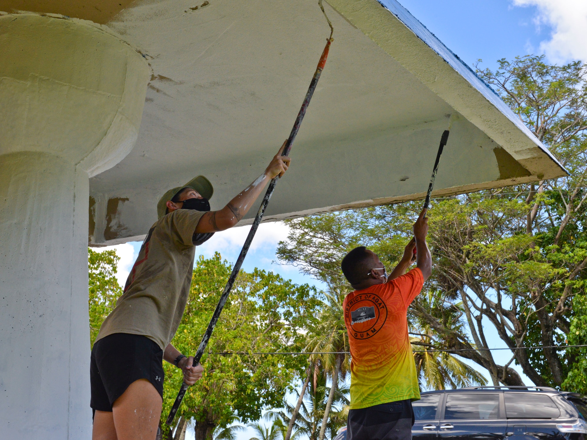 U.S. Air Force Staff Sgt. Kelly Lawson, 36th Healthcare Operations Squadron noncommissioned officer in charge of in-garrison maintenance, and Clide Torres, an Agat Mayor’s Office maintenance worker, paint a bus stop in Agat, Guam, March 20, 2021. Nearly a dozen 36th HCOS Airmen and family members joined Agat Mayor’s Office staff to repaint two village bus stops through the Andersen Air Force Base Sister Village Sister Squadron program, in which squadron volunteers collaborate in events with Guam residents to strengthen their friendship and partnership. (U.S. Air Force photo by Alana Chargualaf)