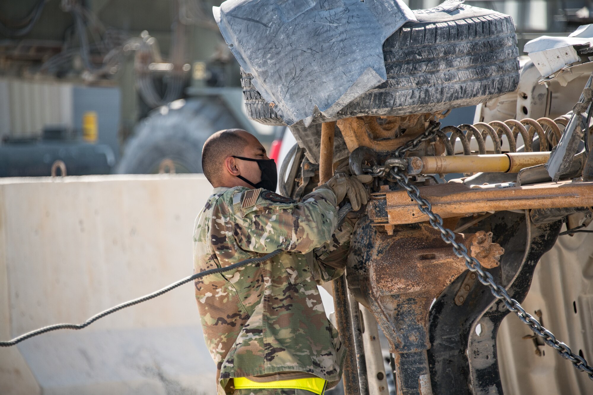 a man attaches a chain to an axle