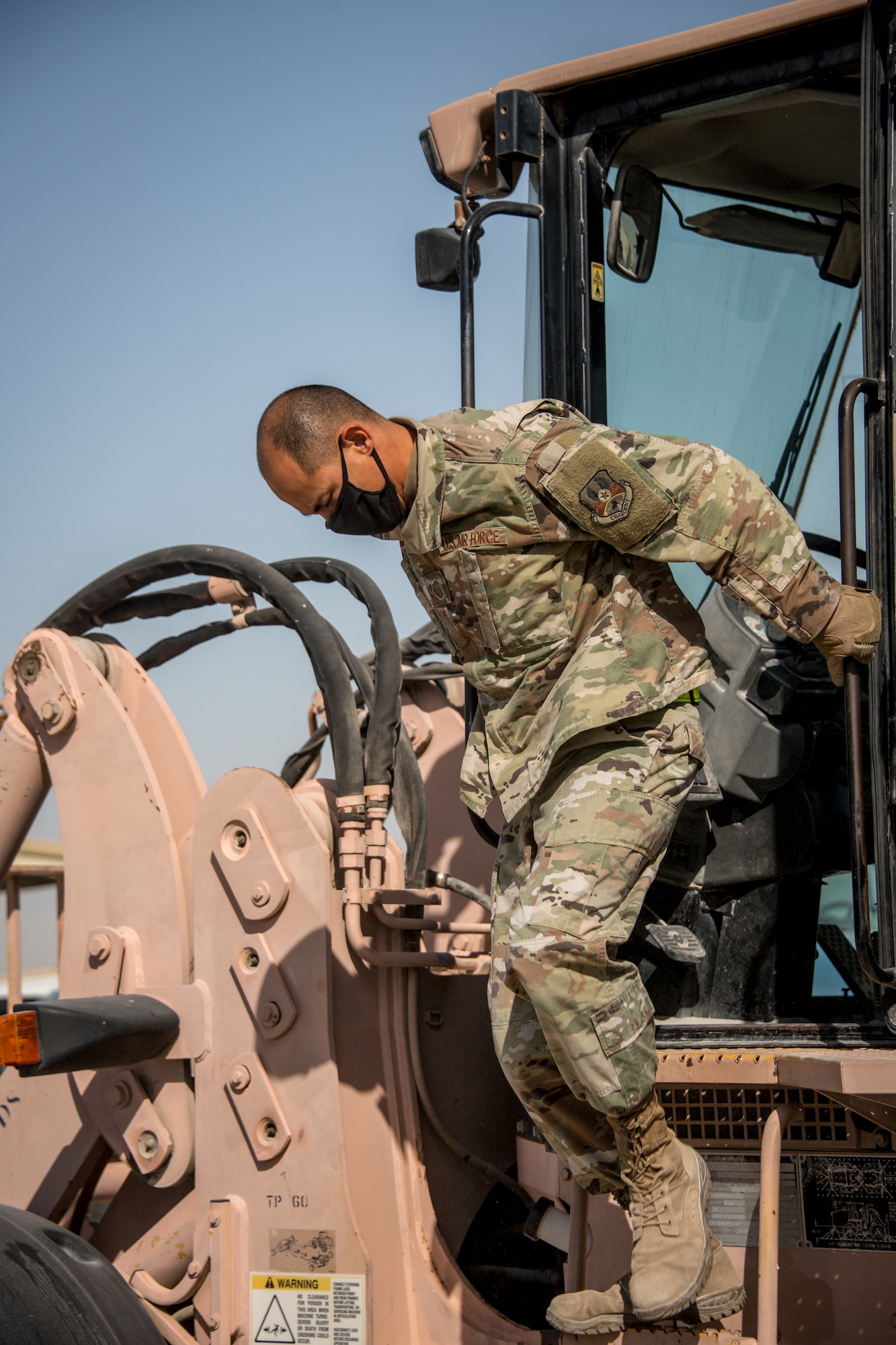 An airman exits a forklift