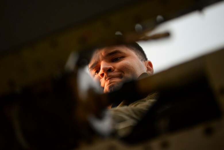 A maintainer performs maintenance on a jet.