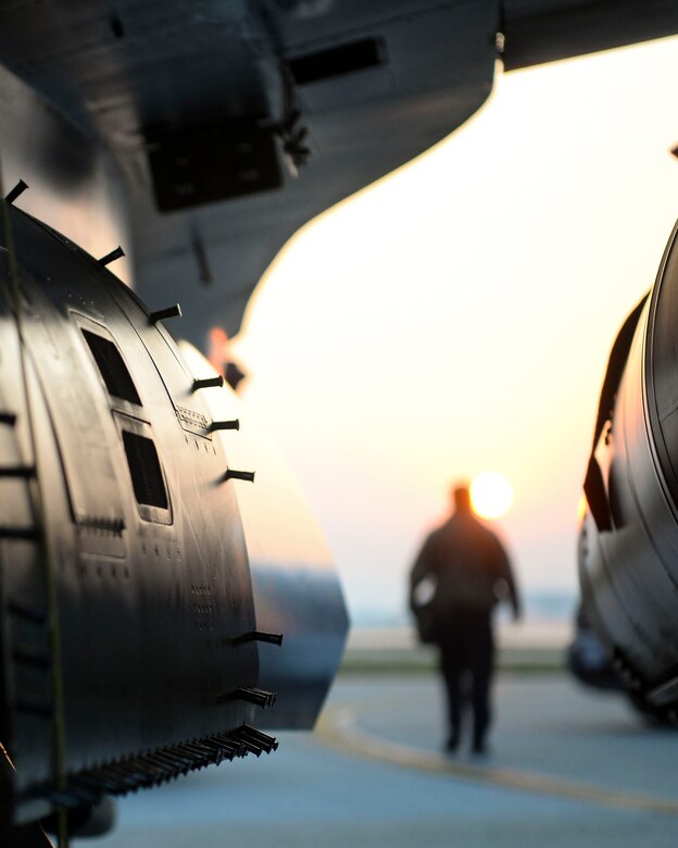 A crew chief walks toward a jet.