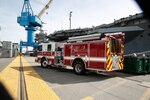 Norfolk Naval Shipyard's Fire Engine 22 with the USS Harry S. Truman (CVN 75) in the background.