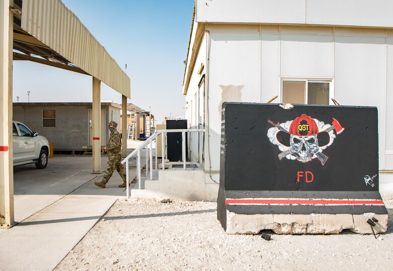 A man walks on a sidewalk between buildings
