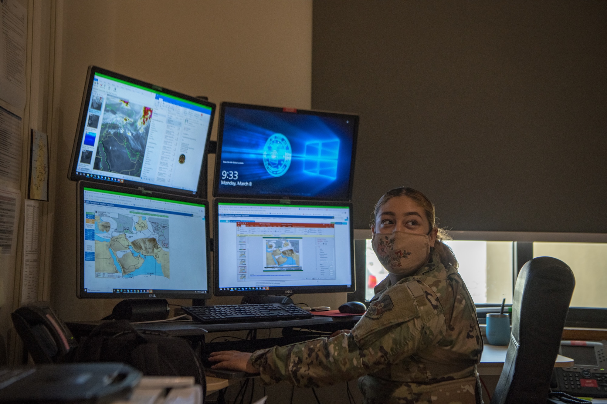 an airman glances behind them in front of computer screens
