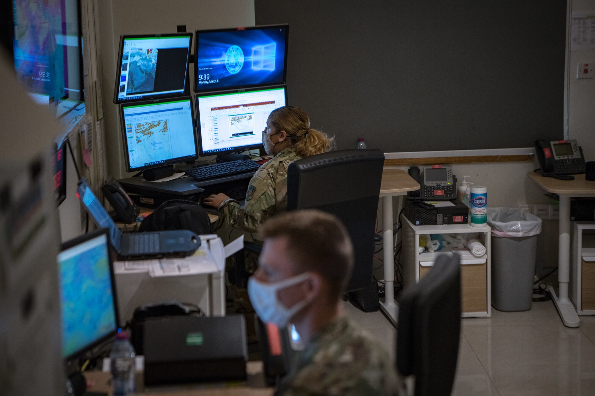 two airmen look at weather maps on computer screens