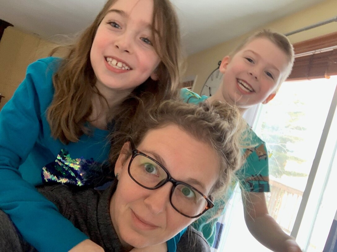 Mom with two kids hanging off her
