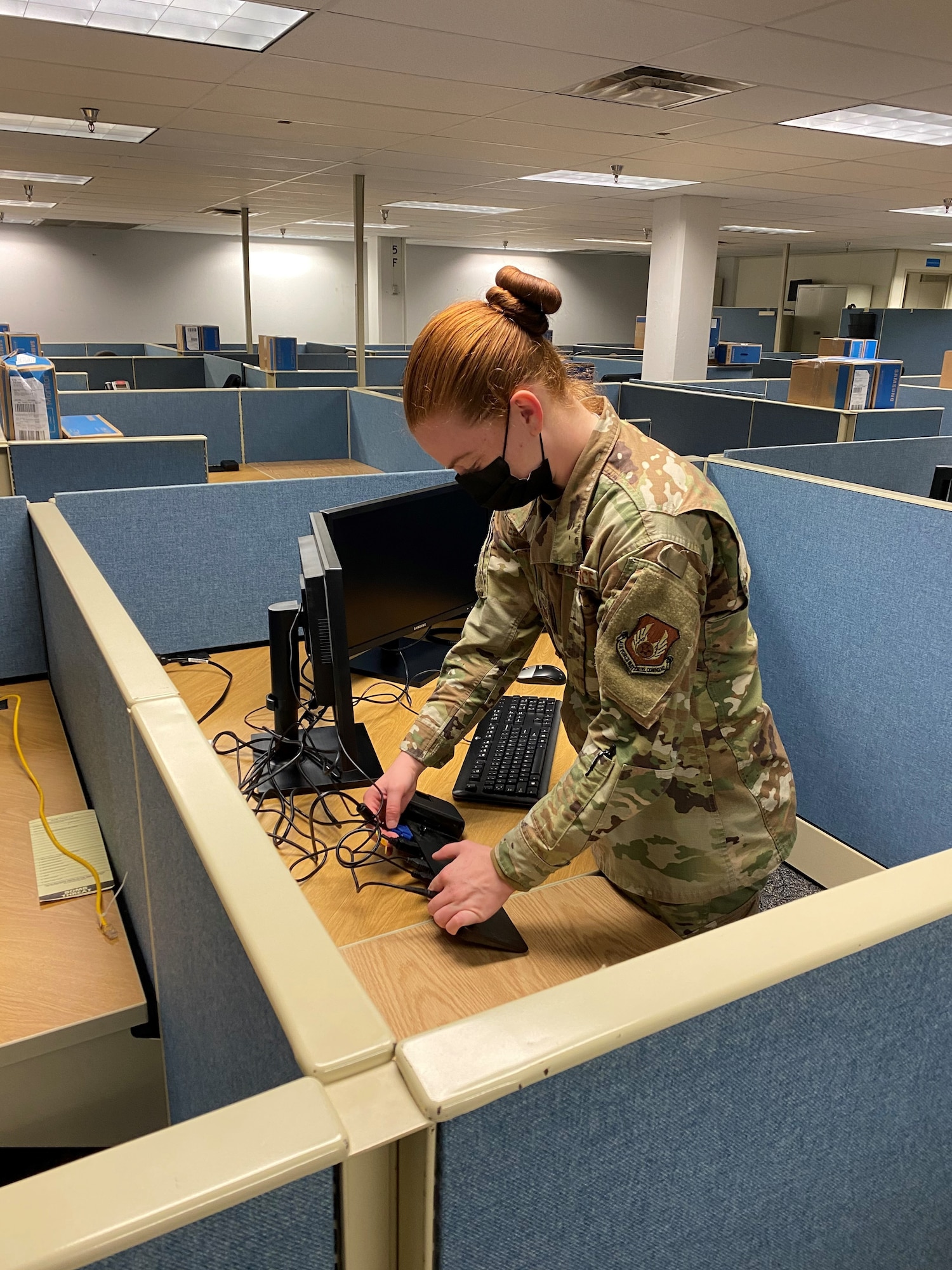 Staff Sgt. Elda Quesenberry connects a new computer work station in preparation for the transitional wave of office moves required by the future renovation of Headquarters AFMC, 
Bldg. 262/266.