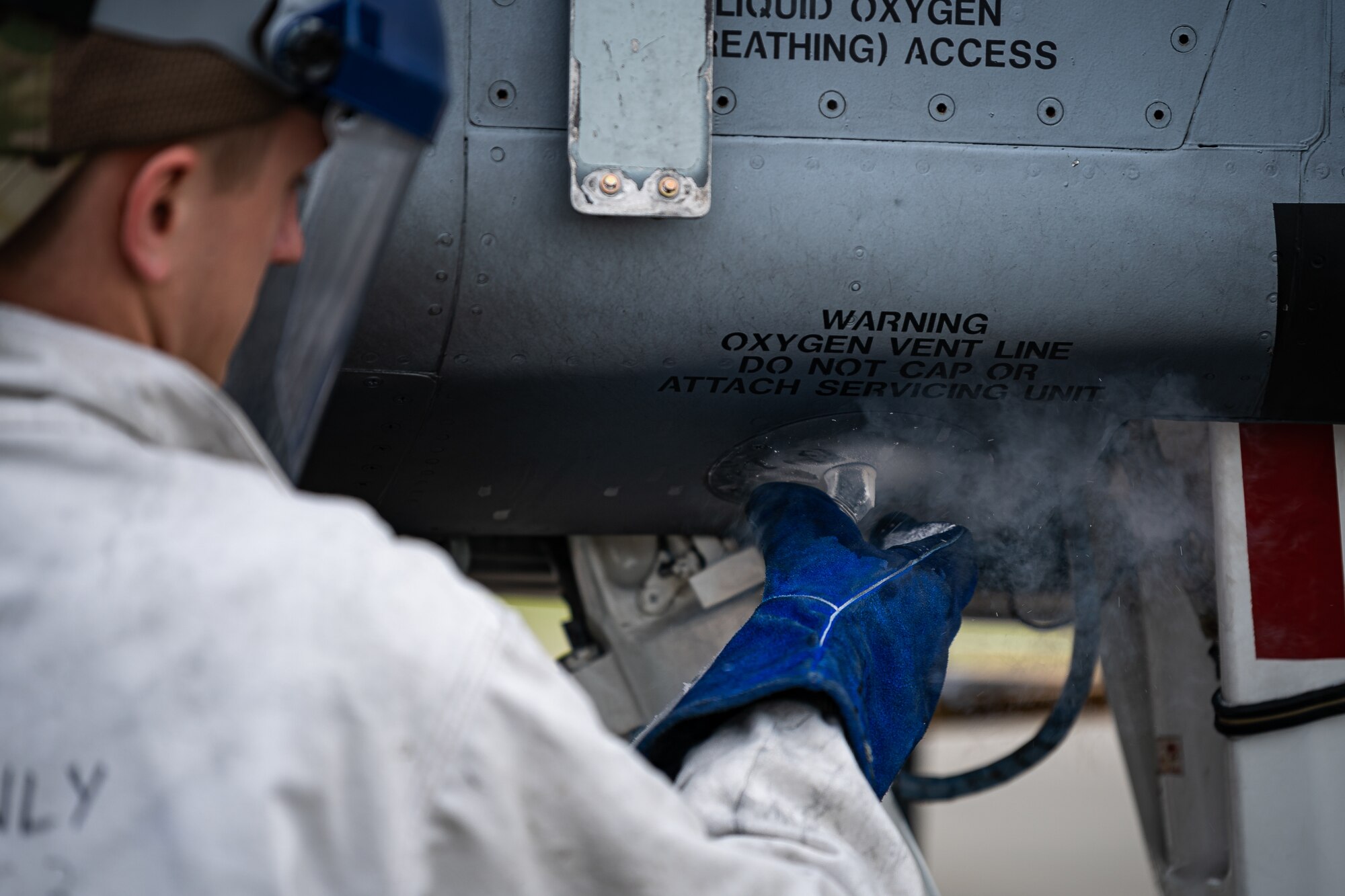 A photo of an Airman removing a liquid oxygen vent line