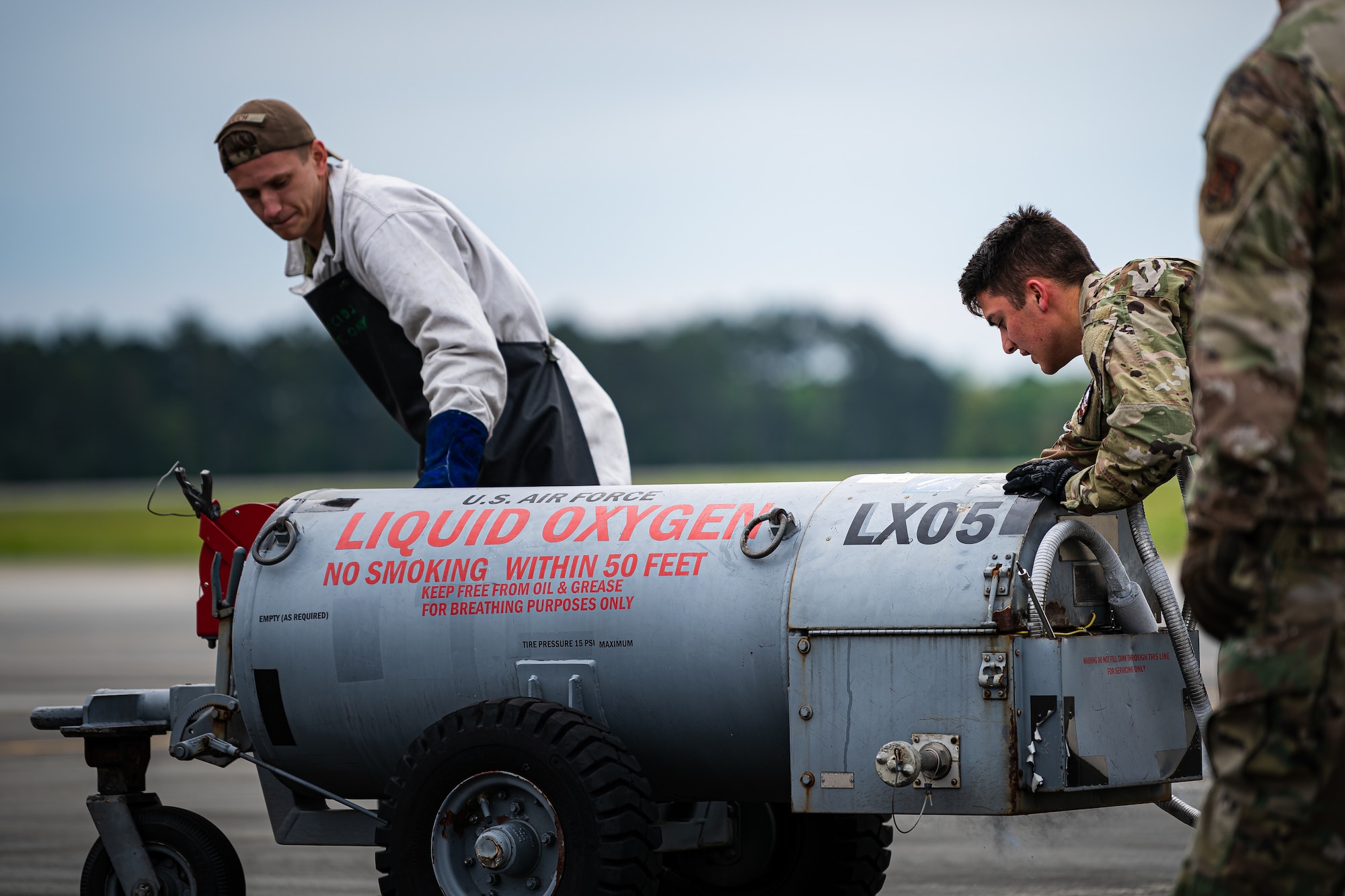 A photo of Airmen pushing a liquid oxygen cart