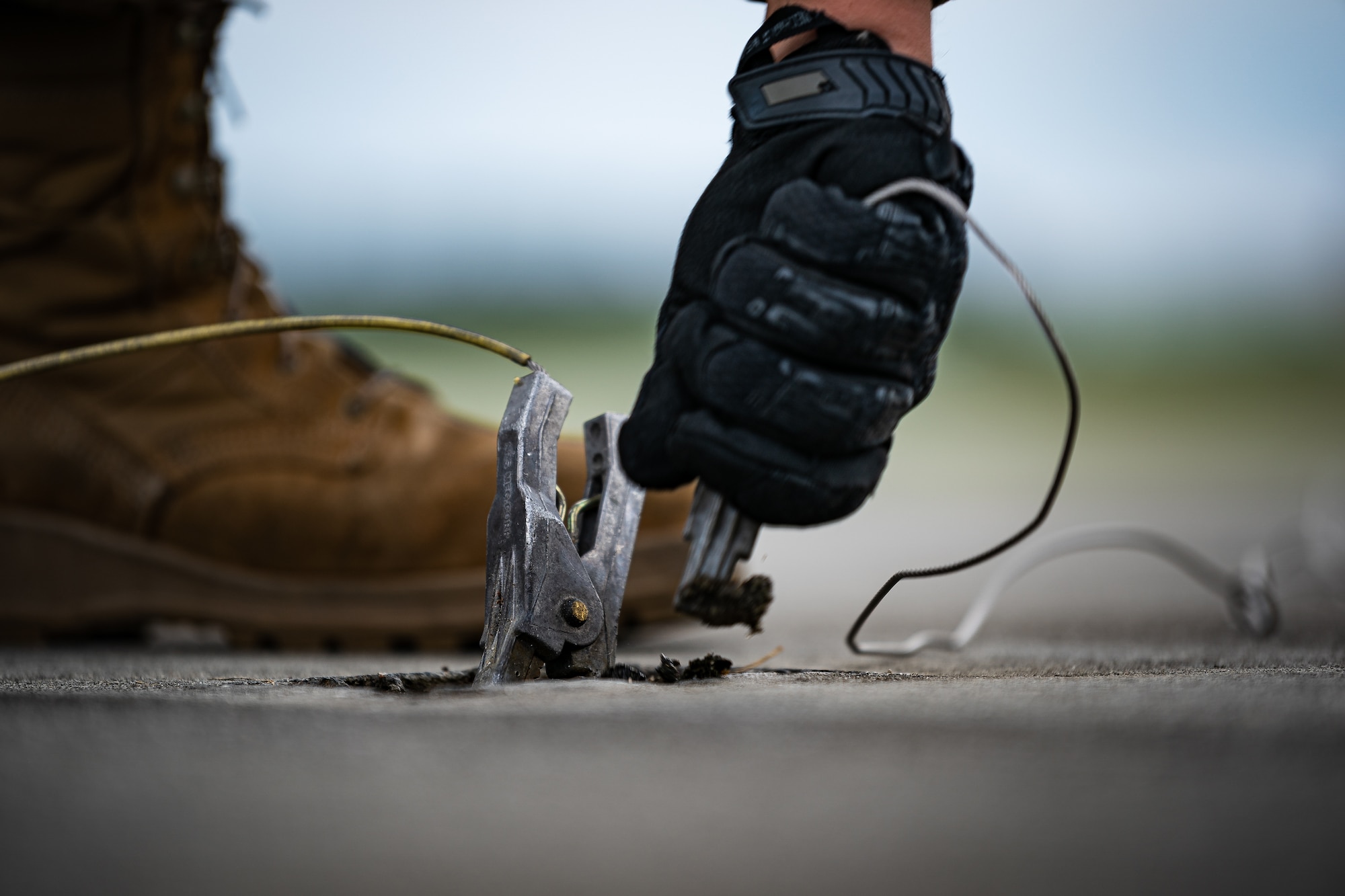 A photo of an Airman removing a grounding clamp