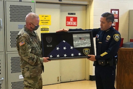 Lynchburg Police Chief Ryan Zuidema presents a flag flown over the headquarter building of the Lynchburg Police Department to Lt. Col. Jim Tierney, commander of 1st Battalion, 116th Infantry Regiment, 116th Infantry Brigade Combat Team, as a thank you for support support to civilian law enforcement during protests in Lynchburg in June 2020.