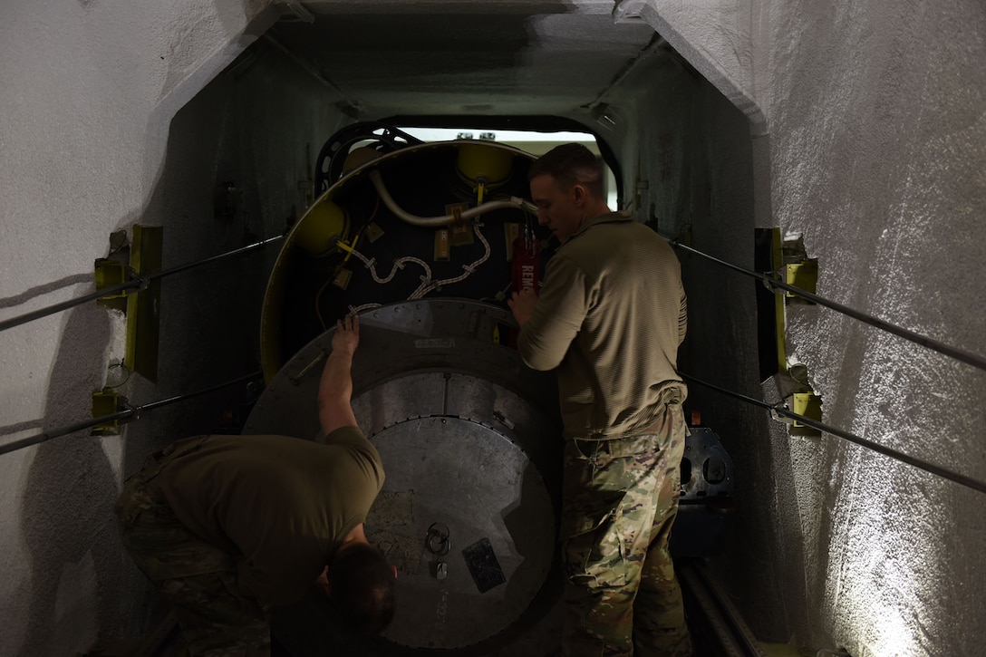 Two Airmen work inside of the T.E. prepping the booster for a roll transfer.