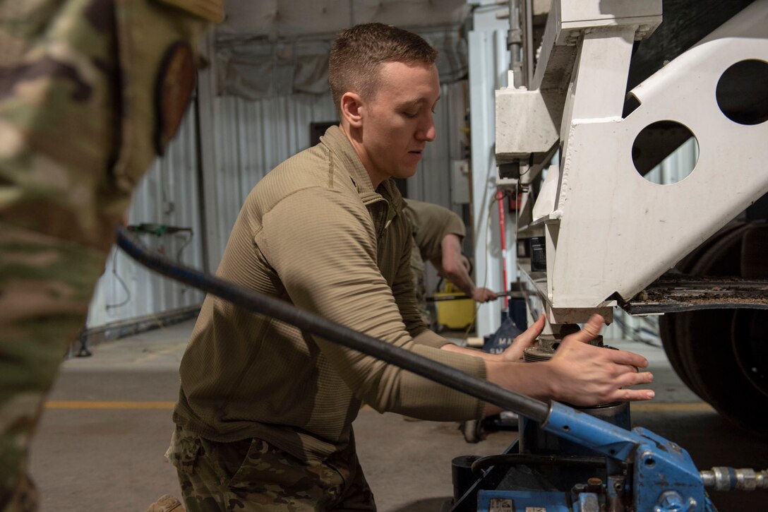 Airman levels the rear of the transporter erector so the missile can be transported from one vehicle to another without incurring damage.