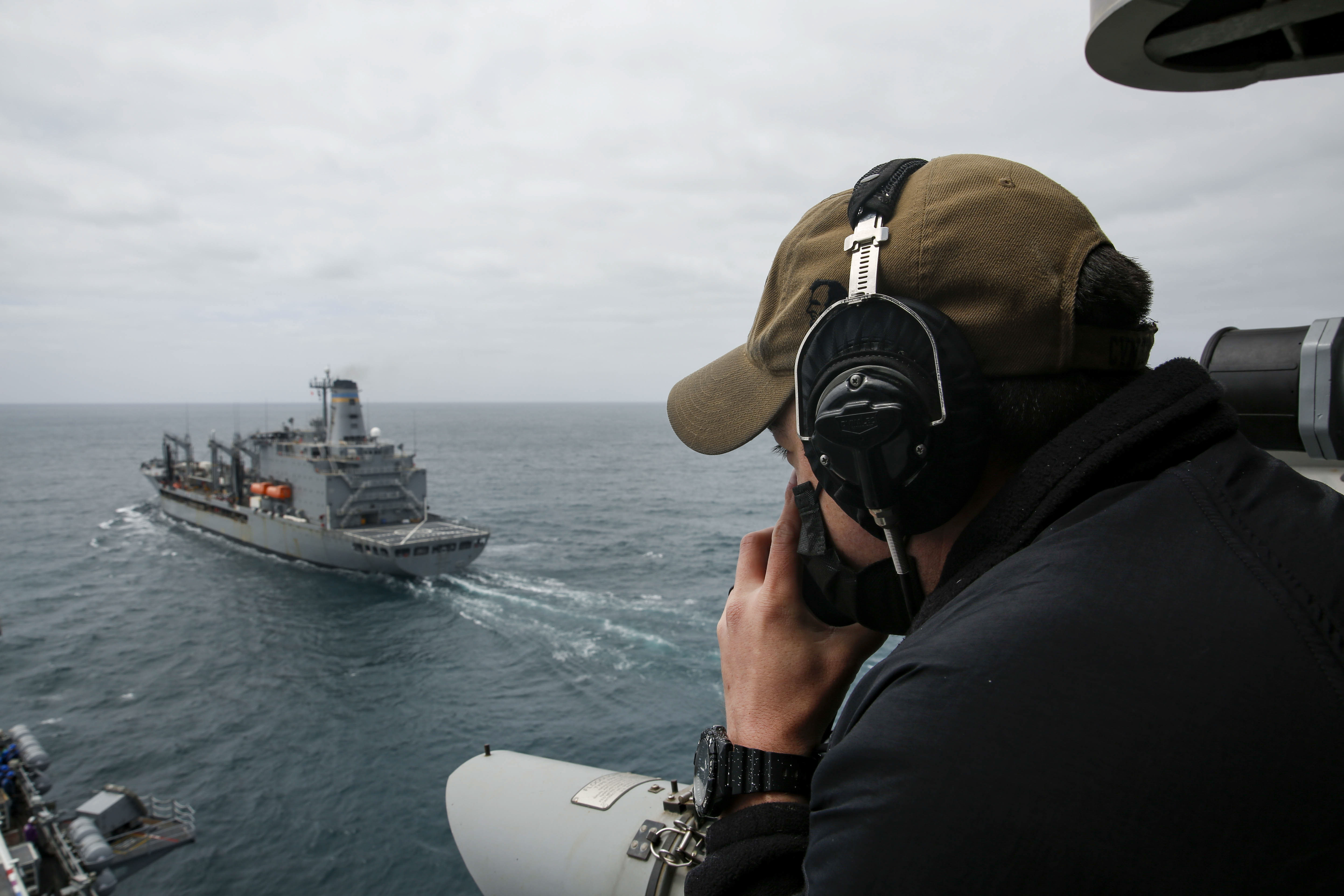 A Sailor stands forward lookout watch as the aircraft carrier USS Abraham Lincoln (CVN 72) approaches the fleet replenishment oiler USNS Henry J. Kaiser (T-AO 187) prior to a replenishment-at-sea.
