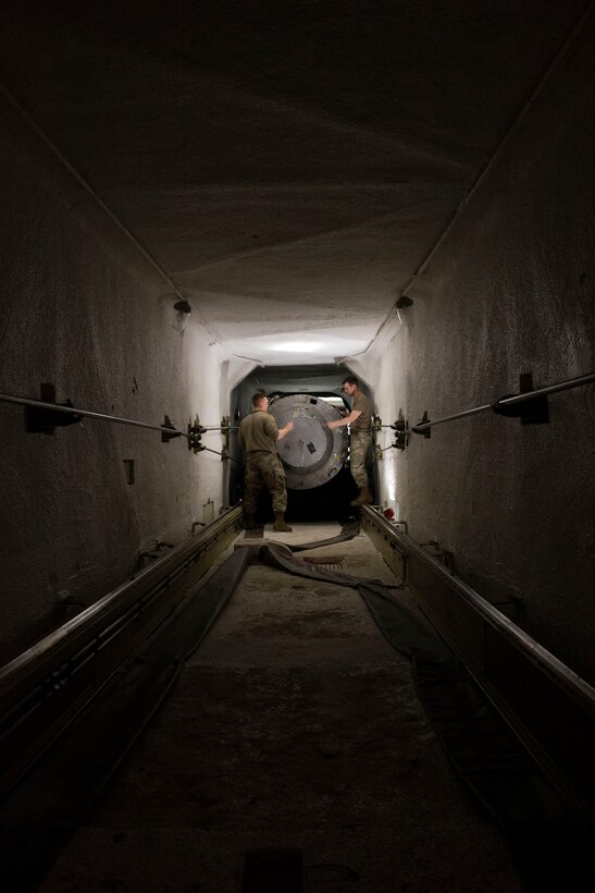 People in a tunnel secure a missile.