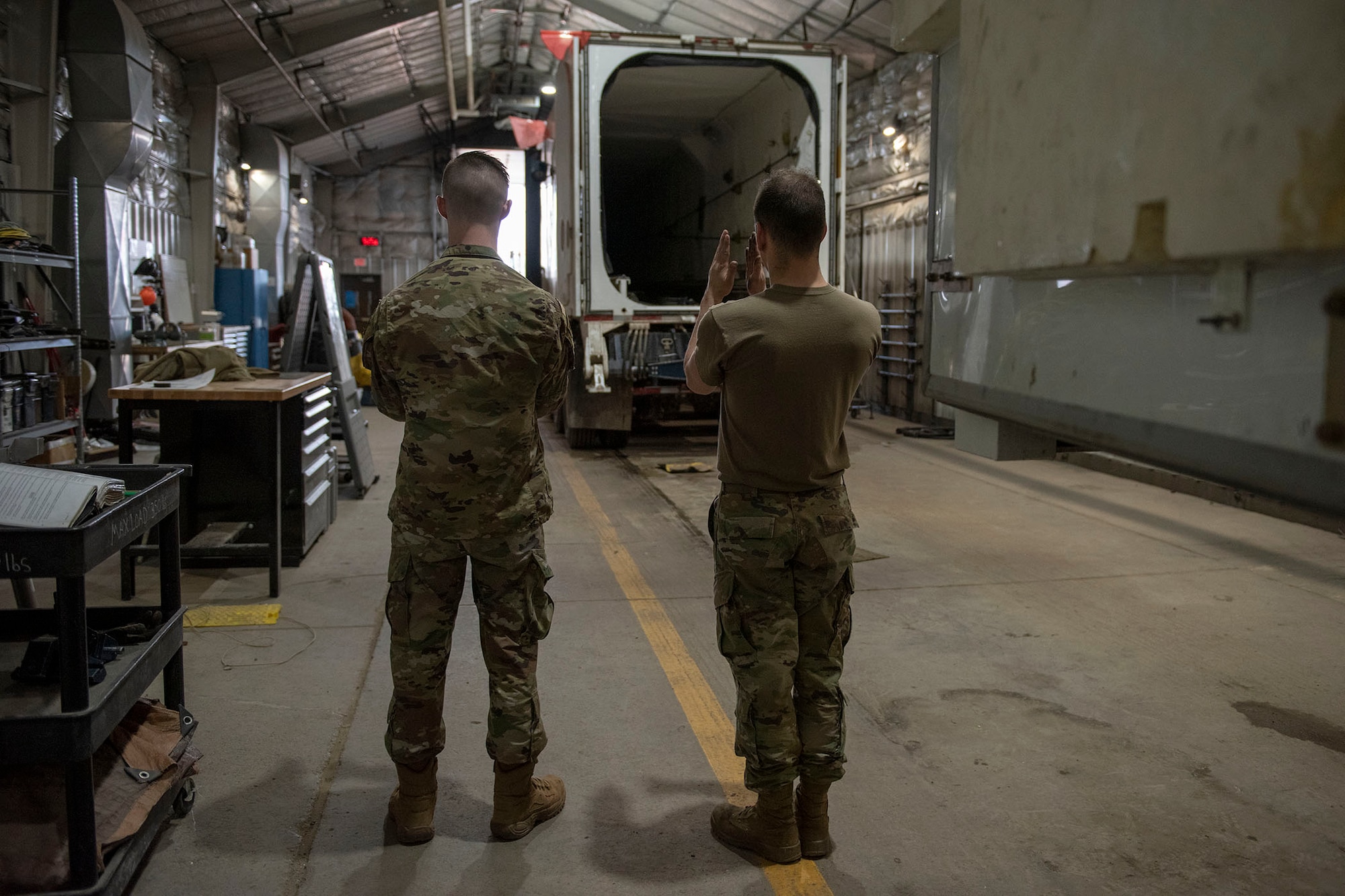 The team chief guides a transporter erector inside the hanger for the start of the missile roll transfer.