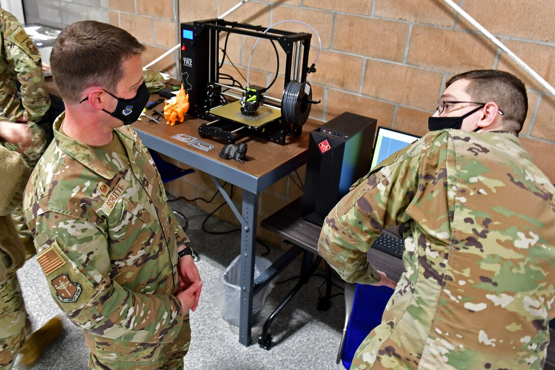 An Airman demonstrates a 3D printer
