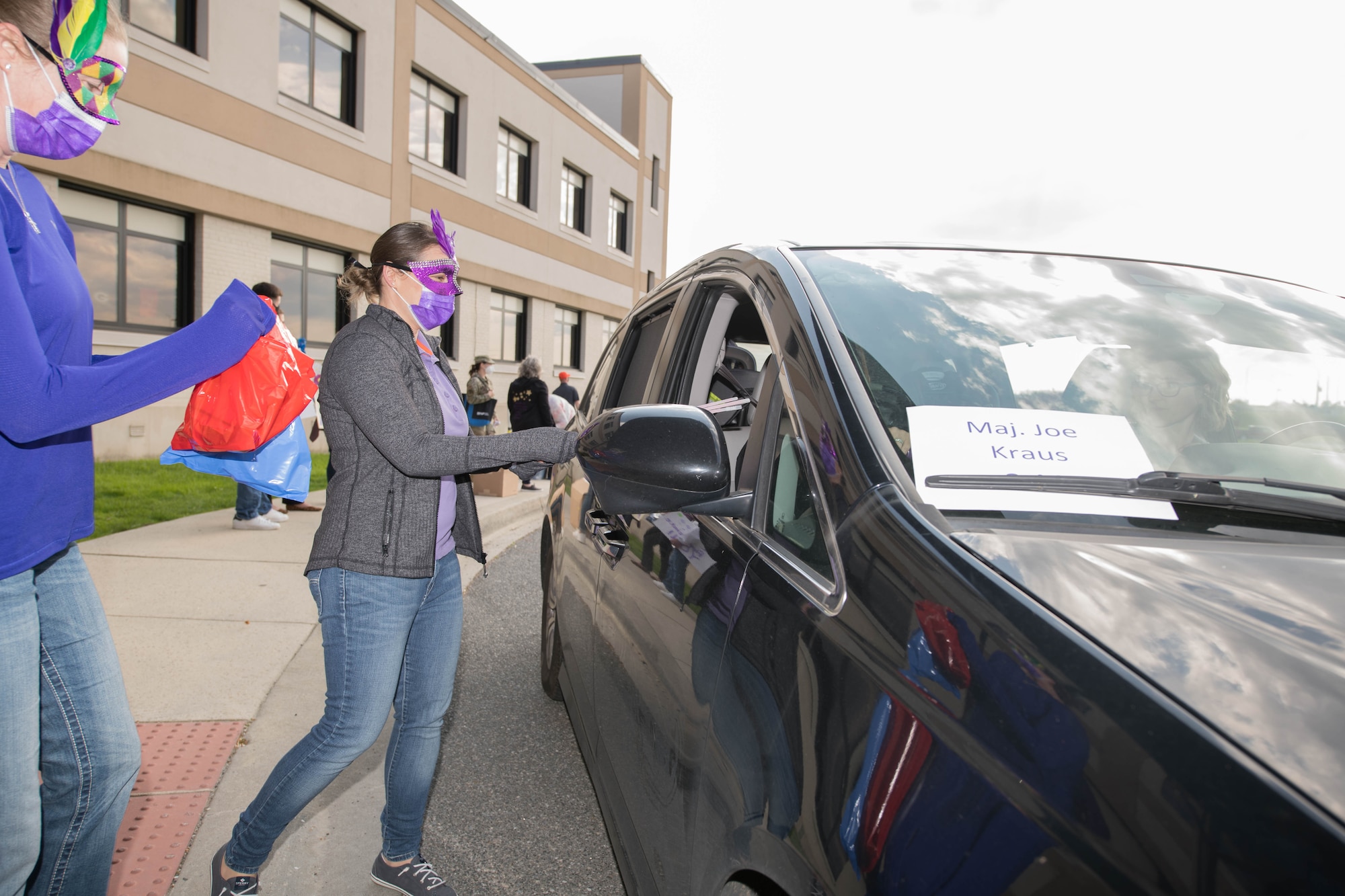 Members of the 436th Health Care Operations Squadron hand out gift bags at the deployed families dinner hosted by the 436th Medical Group on Dover Air Force Base, Delaware, April 15, 2021. Families received informational packets, gift buckets of family activities, potted flowers and bagged dinners during the drive-thru event. (U.S. Air Force photo by Mauricio Campino)