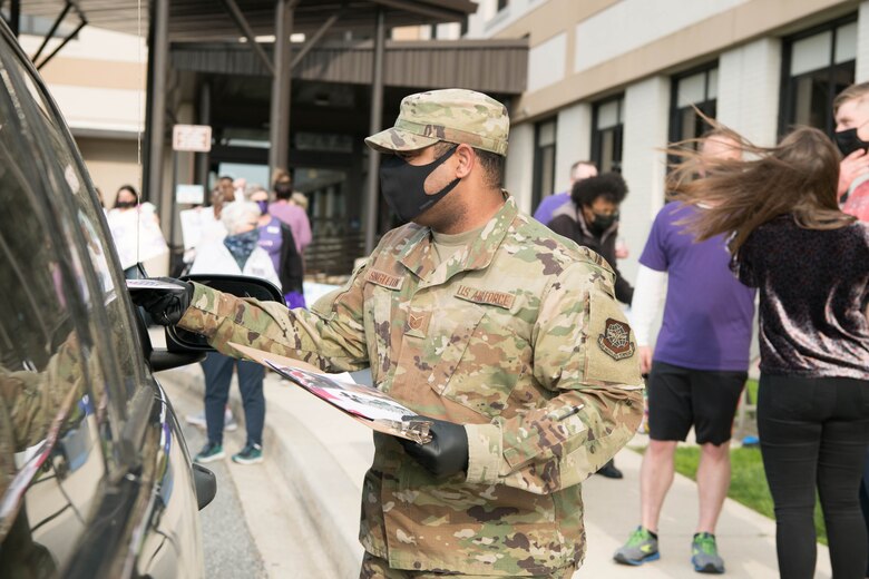 Tech Sgt. Dominique Singleton, 436th Force Support Squadron wing readiness noncommissioned officer in charge, hands out informational packets at the deployed families dinner hosted by the 436th Medical Group on Dover Air Force Base, Delaware, April 15, 2021. More than twenty families of deployed Airmen registered for the event. (U.S. Air Force photo by Mauricio Campino)