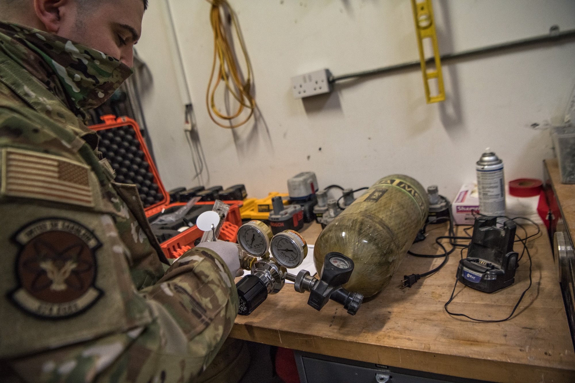 A man tests a self contained breathing apparatus on a table