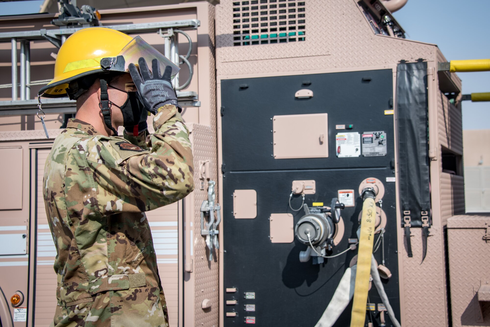 an airman dons a fire helmet