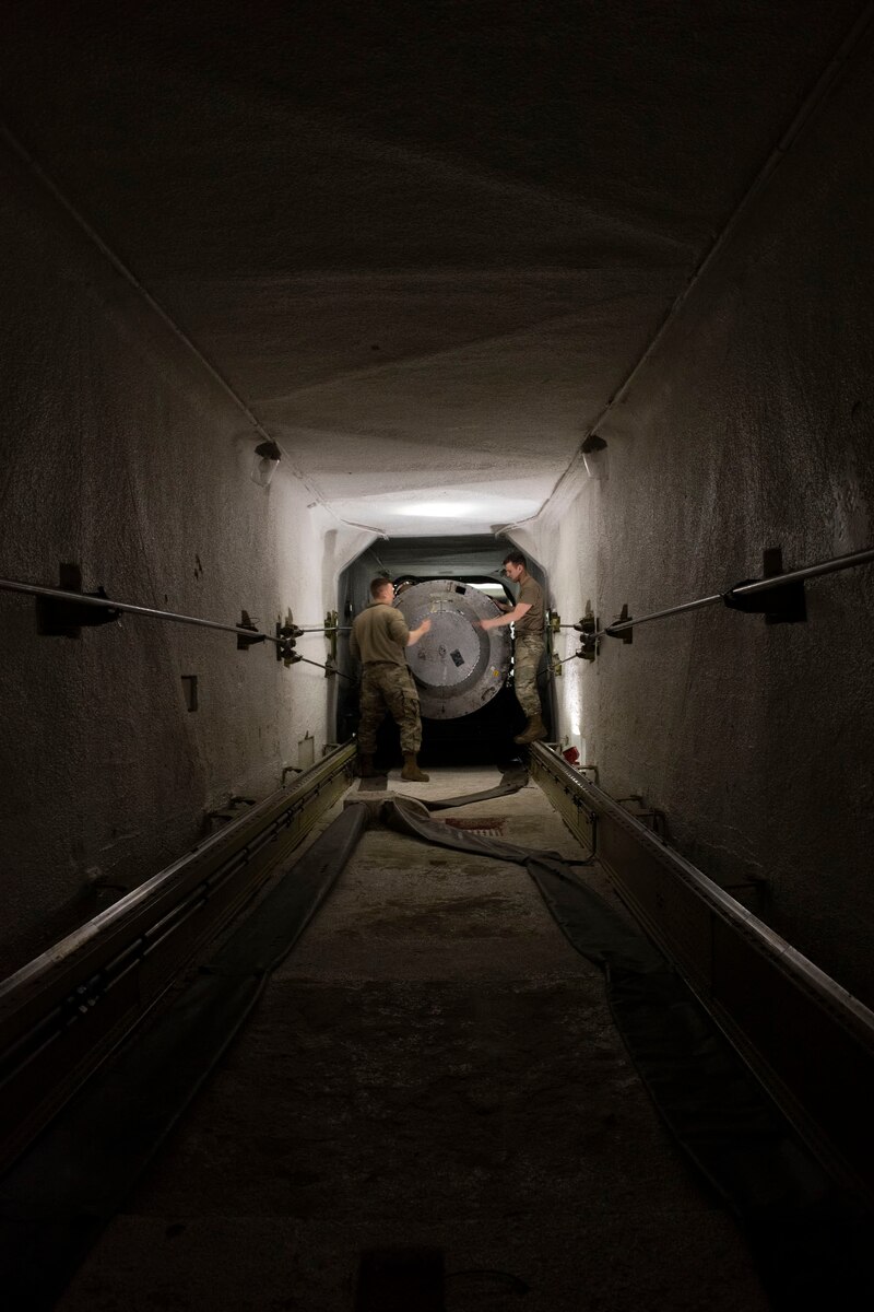 People in a tunnel secure a missile.